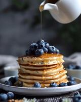 AI generated Gluten free vegan blueberry pancakes, blueberries on top of pancakes and around, The cup is watering the pancakes from above photo