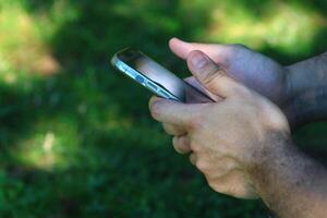 un masculino mano relación comercial con un teléfono inteligente foto