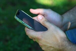 un masculino mano relación comercial con un teléfono inteligente foto