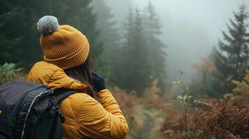 AI generated Autumn . Woman puts on knitted hat during hike in mountains forest in cold foggy weather photo