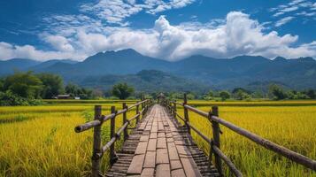 AI generated wooden bridge stretches across the yellow rice fields with mountains clouds and blue sky in background photo