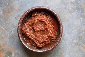 AI generated Harissa sauce, made from hot red pepper, garlic and spices. Top view. AI created. photo
