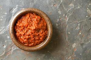 AI generated Harissa sauce, made from hot red pepper, garlic and spices. Top view. AI created. photo