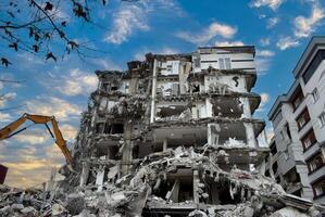 Buildings collapsed after the earthquake. Vehicles working after the earthquake. photo