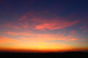 avión y sus sendero en el cielo. nubes y diferente color tonos en el cielo a puesta de sol. increíble y increíble puesta de sol. foto