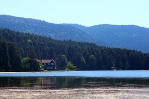 House on the shore of lake. Reflected on water. Country side, forest, farm field, lake with house. Bolu,Turkey photo