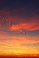 avión y sus sendero en el cielo. nubes y diferente color tonos en el cielo a puesta de sol. increíble y increíble puesta de sol. foto