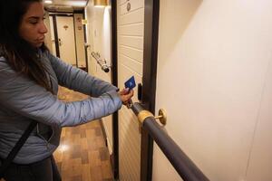 Beautiful latin woman using a proximity card to unlock the hotel room door. Digital or keyless to authenticate. Wireless technology. photo