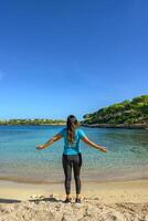 latina woman, on the shore of the beach looking at the sea breathing deeply photo