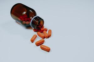 Pill bottle spilled in surface isolated on white background. photo