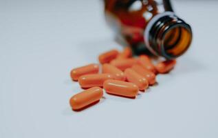 Selective focus. Blurred. Pill bottle spilled in surface isolated on white background. photo