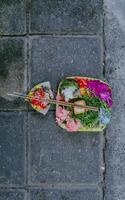 Canang sari, balinés ofrendas en un Roca pared. pequeño religiones ofrecimiento hecho fuera de flores tradicional diario en bali ofrendas. foto