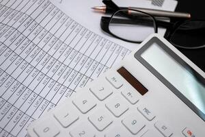 Financial documents and white calculators on black wooden desks photo