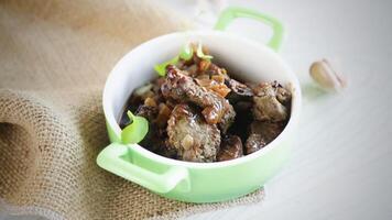 fried liver with onions and spices in a plate on the table video