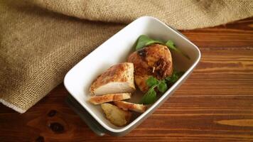 baked chicken fillet pieces with spices and herbs, in a ceramic form on a wooden table video