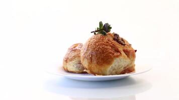 Sweet curled bun with jam, raisins in powdered sugar on a plate video