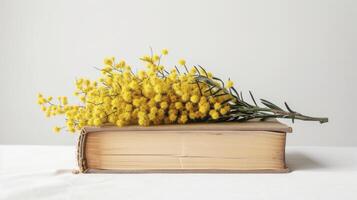 AI generated A book with yellow mimosa flowers photo