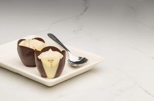 Two Tuxedo Dark Chocolate Mousse Cups on a White Plate photo