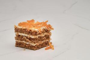 Slice of Carrot Cake Topped with Fresh Carrot on a White Marble Surface photo
