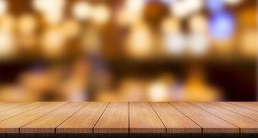 Empty wooden table top with lights bokeh on blur restaurant background. photo