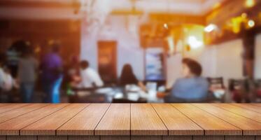 Empty wooden table top with lights bokeh on blur restaurant background. photo