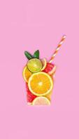 Creative flat lay juice concept. Sliced citrus orange, lime, grapefruit, lemon, fruits make juice glass shape flat lay pink background vertical video stopmotion animation