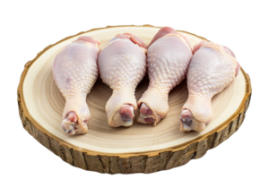 AI generated Four raw chicken drumsticks arranged on a round wooden cutting board isolated on transparent background, png