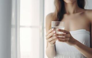 AI generated Blonde girl holding glass of water in the morning at home photo