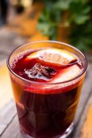 caliente reflexionado vino en un vaso en un mesa en un calle cafetería. estacional caliente bebidas acogedor atmósfera. de cerca. selectivo enfocar. foto