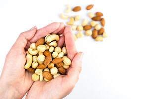 Woman's hands hold a mix of dried nuts. Healthy food concept. Close-up. Top view. photo