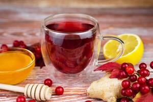 Tea from viburnum berries with ginger, lemon and honey. Alternative medicine. Close-up. Selective focus. photo