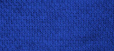 Texture of knitted wool fabric with of a blue color. Top view. Close-up. Banner. Selective focus. photo