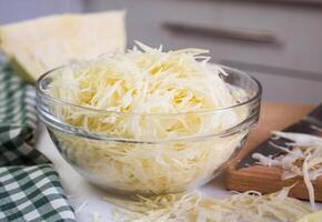 Chopped cabbage in a glass bowl on the table. Healthy food concept. Close-up. Selective focus. photo