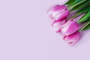 hermosa ramo de flores de rosado tulipanes en rosado antecedentes. saludo tarjeta para madres día, marzo 8, San Valentín día, cumpleaños. bandera. Copiar espacio. de cerca. parte superior vista. foto