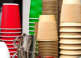 A stack of disposable paper cups and cupc in a cafe. Coffee to go. Close-up. Selective focus. photo