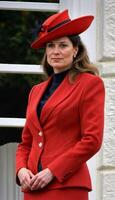 AI generated photo of beautiful lady europe woman with red coat and hat standing at garden, generative AI