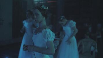 Caucasian female ballet dancer standing behind a stage curtain and waiting backstage to enter the stage for her performance. Graceful ballerina standing behind the scenes and dreaming to perform. video