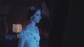 Caucasian female ballet dancer standing behind a stage curtain and waiting backstage to enter the stage for her performance. Graceful ballerina standing behind the scenes and dreaming to perform. video