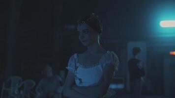 Caucasian female ballet dancer standing behind a stage curtain and waiting backstage to enter the stage for her performance. Graceful ballerina standing behind the scenes and dreaming to perform. video