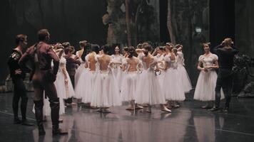Russia, Astrachan, 22.08.2024. A group of ballerinas and a choreographer, standing on the stage, discuss the performance after the performance. Ballet dancers are resting. correction of mistakes. video