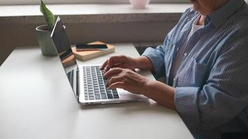 de cerca mujer de negocios manos mecanografía ordenador portátil teclado en abierto espacio. grave gerente mensajería con cliente a lugar de trabajo. retrato de sonriente mujer trabajando en ordenador portátil computadora en oficina video