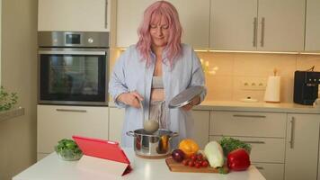 Pretty woman cooking soup on stove at kitchen. Close up of housewife preparing dinner at home. video