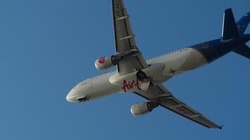 PHUKET, THAILAND - FEBRUARY 20, 2023. Passenger plane Airbus A320, HS-ABT of AirAsia is flying overhead. Airplane in the blue sky. Travel concept video