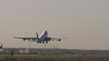 Heavy cargo plane with unrecognizable livery taking off and climbing, rear view video