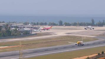 PHUKET, THAILAND - FEBRUARY 23, 2023. Long shot, passenger plane Boeing 737, HS-DBT of Nok Air is taking off at Phuket airport, panoramic view of the airfield. Aircraft departure, side view video