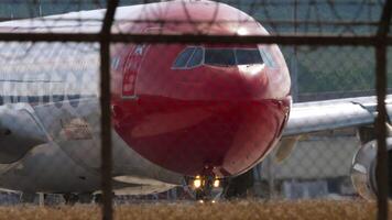 PHUKET, THAILAND - JANUARY 26, 2023. Airbus A340-313, HB-JME of Edelweiss Air taxiing to the runway at Phuket airport. Board behind the airport fence. Edelweiss Air Swiss charter airline video