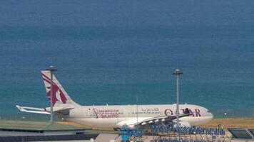 phuket, thailand - februari 22, 2023. flygbuss a330-202, a7-acm av qatar luftvägarna taxning till de bana på phuket flygplats. antal fot av en jet plan på de flygfält, hav bakgrund video