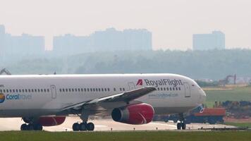 MOSCOW, RUSSIAN FEDERATION - JULY 30, 2021. Passenger plane Boeing 767-3W0, ER, VP-BRE of Royal Flight Airlines taxiing at airport runway, side view, middle shot. Concept travel video