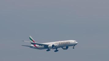 PHUKET, THAILAND - FEBRUARY 27, 2023. Boeing 777-31H, ER, A6-EPB of Emirates approaching landing at Phuket airport. Airliner descending, side view, long shot. Passenger flight arriving video