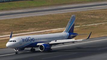 PHUKET, THAILAND - FEBRUARY 23, 2023. Airbus A320-251N, VT-IPH of IndiGo braking after landing at Phuket airport, side view, medium shot. Footage of the airliner arriving. Spoilers up video